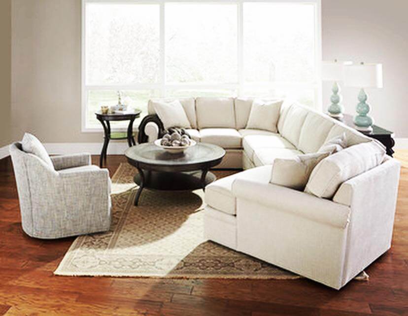L-shaped beige couch surrounding black coffee table