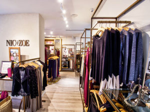 inside store of Nic and Zoe, racks of clothing and store logo