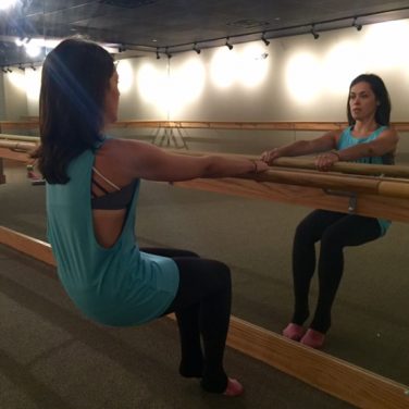 girl working out on ballet bar at Pure Barre